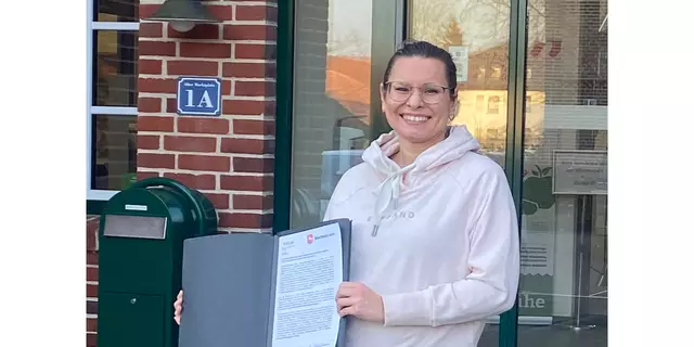 Lühe-Regionalmanagerin Anne Rosenfeld zeigt stolz den Bescheid zur Aufnahme in das Dorfentwicklungsprogramm | Foto: SG Lühe