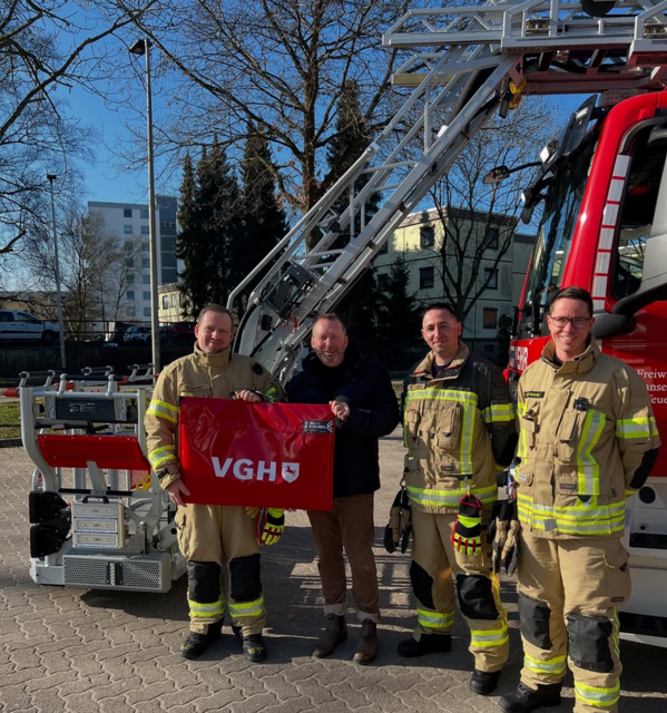 Karsten Holst von der VGH Versicherung überreicht der Feuerwehr den neuen Rauchschutzvorhang  | Foto: Freiwillige Feuerwehr Hansestadt Buxtehude