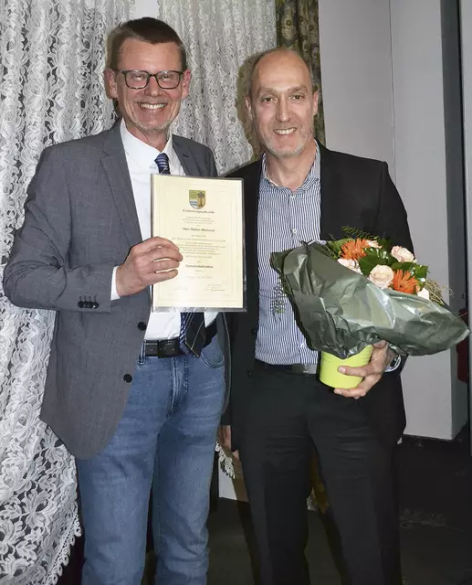 Bürgermeister Uwe Blanck (li.) überreichte Stefan Walnsch die Urkunde fürs Gemeindedirektoramt und Blumen für dessen Frau