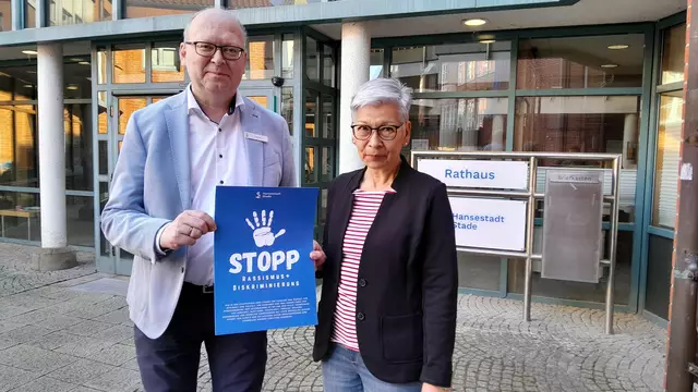 Bürgermeister Sönke Hartlef und Kirsten Bock, Leiterin der Abteilung Sicherheit und Ordnung, präsentieren das Poster, das künftig unter anderem im Einwohnermeldeamt hängt | Foto: Hansestadt Stade