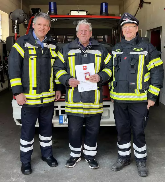 Gemeindebarndmeister Carsten Beneke (li.) und Ortsbrandmeister Axel Brüggemann (re.) ehrten Dieter Lüskow | Foto: Barkow
