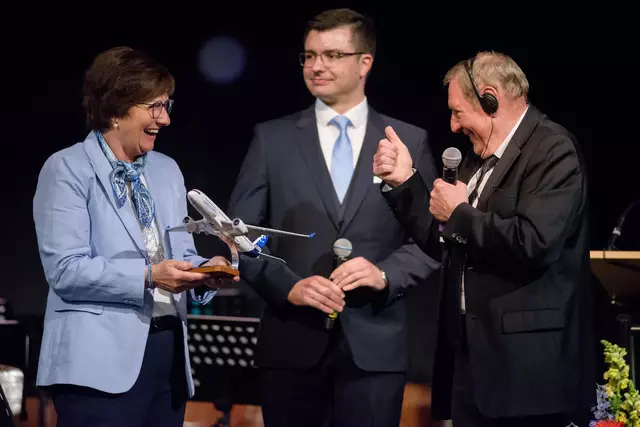 Es geht aufwärts: Katja Oldenburg-Schmidt freut sich über das Gastgeschenk von Joseph Carles (rechts), Alexander Abar half beim Übersetzen | Foto: Jan Iso Jürgens