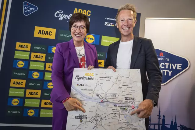 Bürgermeisterin Katja Oldenburg-Schmidt freut sich über die Unterschrift von Fabian Wegmann, Sportlicher Leiter der ADAC Cyclassics und Ex-Profifahrer, auf der Streckenkarte für die Profis | Foto: Henning Angerer