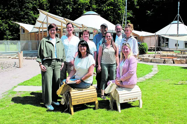 Im Kita-Garten mit den beiden Holzschafen (stehend, v. li.): Bürgermeisterin Katja Oldenburg-Schmidt, Pamela Stallkamp (stellv. Kitaleiterin), Anja Heckert (Ortsbürgermeisterin Neukloster), Krishna Saraswati und Gizem Zeyrek (beide Living Circles GmbH), Florian Kissing und Clara Droop (beide Architekten Horneburg) sowie (vorne, v. li.): Kitaleiterin Cornelia Stein und Birgit Butter (Landtagsabgeordnete und Ortsbürgermeisterin Hedendorf) | Foto: sb
