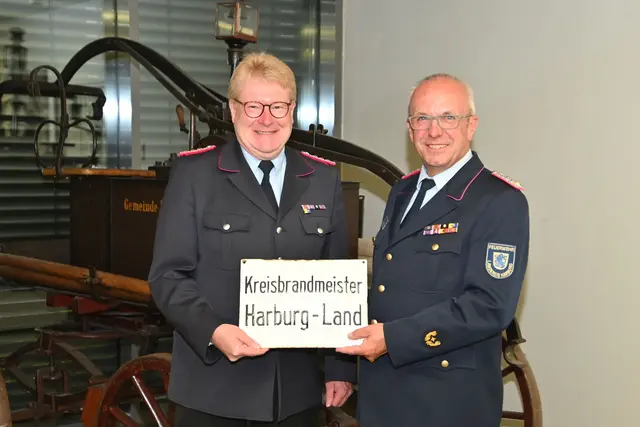 De langjährige Kreisbrandmeister Volker Bellmann (re.) übergab seinem Nachfolger Jörn Petersen ein Emailleschild mit "Berufsbezeichnung" | Foto: Mathias Wille