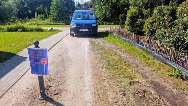 Dieser Fußweg ins Wohngebiet am Redder wurde von Autofahrern als Ausweichpiste missbraucht. Der Poller wurde mehrfach geklaut, ein Feldstein beiseite geschoben. Jetzt blockiert ein Fahrzeug des Ordnungsamtes den Weg | Foto: jd