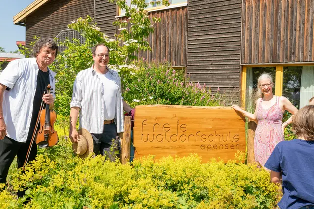 Ingolf Linau (li.), von der Kreisjugendmusikschule, Martin Harlan, Lehrer und Vorstand des Trägervereins, und Friderike Steinkopff, Gründungsmutter und zuständig für die Öffentlichkeitsarbeit, feiern die Enthüllung des neuen Logos vor der Schule | Foto: Waldorfschule Apensen