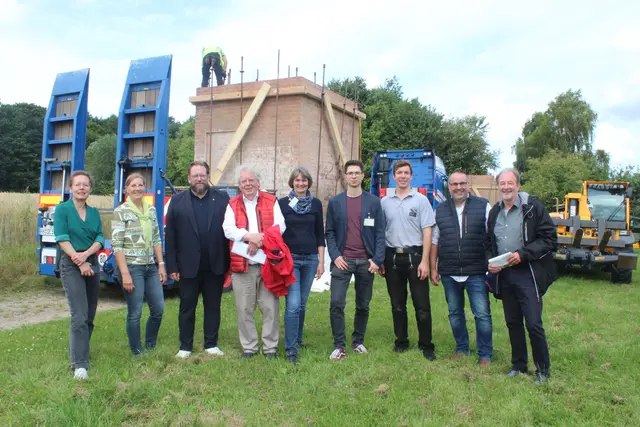 Vor einem Teil des abgebauten Trafoturms (v. li.): Carina Meyer (Kaufmännische Geschäftsführerin, FLMK), Sybille Kahnenbley (Stiftungsratsvorsitzende), Museumsdirektor Stefan Zimmermann, Christian Popp (Erster Vorsitzender des Heimatvereins Ashausen), Theda Pahl (Architektin, FLMK), Chris Stölting (Leiter der Abteilung Wissenschaft , Ausstellung und Sammlung, FLMK), Ingo Schad (Projektsteuerung Translozierung der JaKo Baudenkmalpflege GmbH), Jan Bauer (Erster Vorsitzender des Fördervereins) sowie Robert Isernhagen (Bürgermeister der Gemeinde Stelle) | Foto: pm