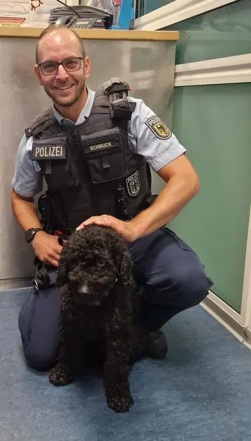 Ein Bundespolizist mit Pudel "Goofy", der auf der Wache versorgt wurde | Foto: Bundespolizei