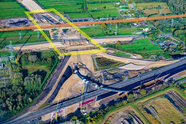 Die Baustelle des Hafenbahntunnels (gelb umrandet) und der Anschluss der A26 an die A7 vor rund einem halben Jahr. Die orange Linie zeigt den Verlauf der Hafenbahn. Im Vordergrund die Autobahn A7 | Foto: Martin Elsen/nord-luftbilder.de