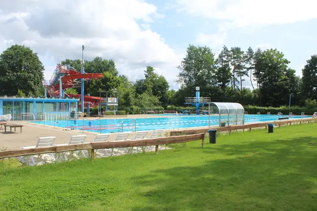 Grüne Liegewiesen und Blick auf die 50-Meter-Bahn, den Sprungturm und die Rutsche | Foto: pm