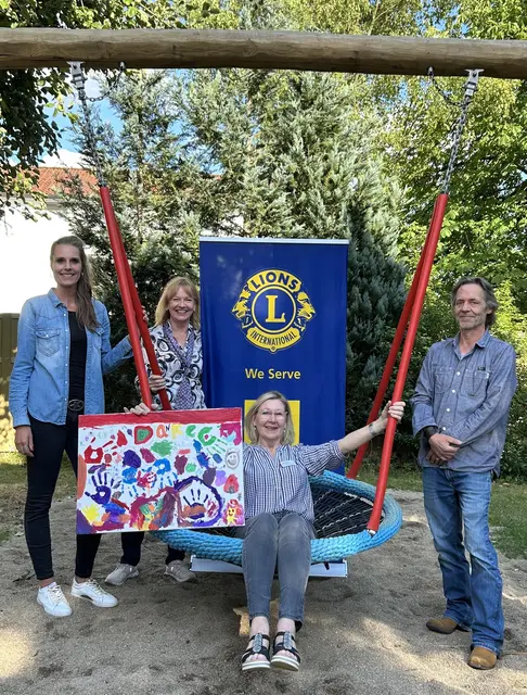 In und neben der Nestschaukel (v. li.): Erzieherin Christiane Schmidt, Angela Mathea, Elisabeth Meinhold-Engbers (Geschäftsführung AWO-Kreisverband Harburg-Land e.V.) und Tim Besendahl, der mit seiner Firma die Schaukel realisiert hat | Foto: Lionsclub Buchholzer Löwen