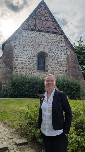 Pastorin Anna-Lena Hübsch vor der Hittfelder Mauritiuskirche.  | Foto: A. Hübsch