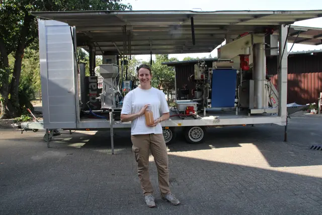 Gesa Gerken mit einer Flasche friss gepresstem Apfelsaft vor ihrer neuen Saftanlage
