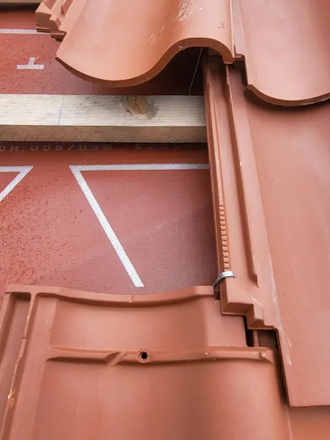 Jede einzelne Ziegel wird präventiv mit Klammern befestigt, damit sie auch wirklich gut hält. Schließlich mit hohem Aufwand verbunden, bei einem Schaden auf das Dach zu kommen, wenn das Gerüst wieder abgebaut ist.