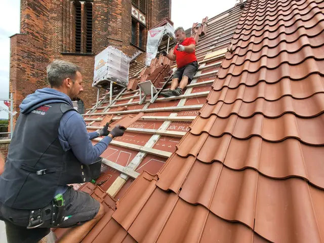 Fachhelfer Jürgen Eichmann (oben) wirft dem Gesellen Christian Gärner die Ziegel zu, die auf dem Steildach mit Klammern befestigt werden