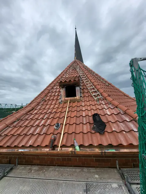 Die Ziegel auf den Flächen des Steildachs werden geklammert, die auf dem First und auf dem Grat (den Dachkanten) nach traditioneller Handwerkstechnik mit Mörtel befestigt