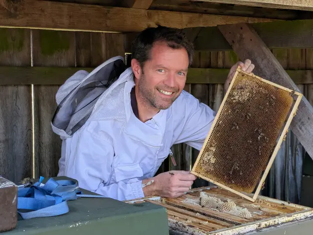 Reiner Stamm, Vorsitzender des Imkerverein Buchholz, zeigt eine Wabe seines Heidehonigs | Foto: Imkerverein Buchholz