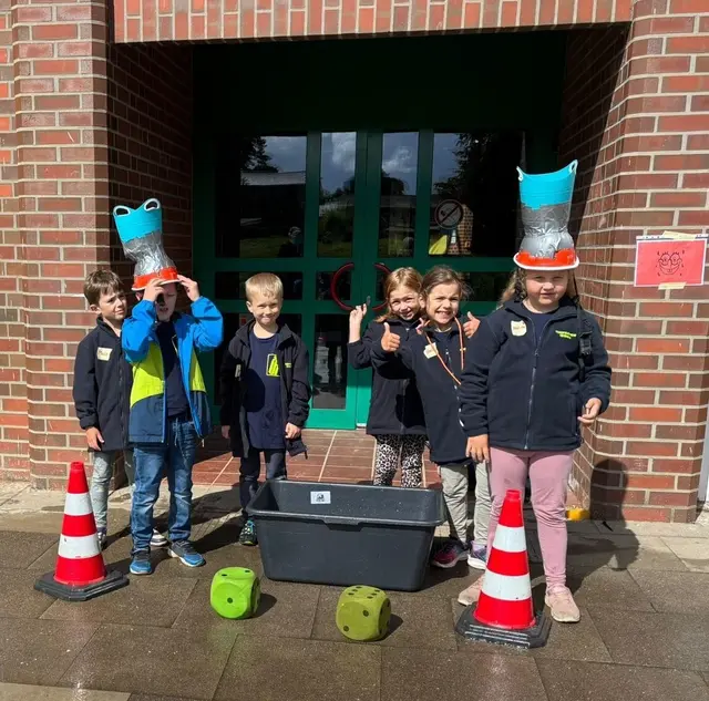 Bei der Station Spongebob balancieren Kinder einen befüllten Helm | Foto: FF Tötensen