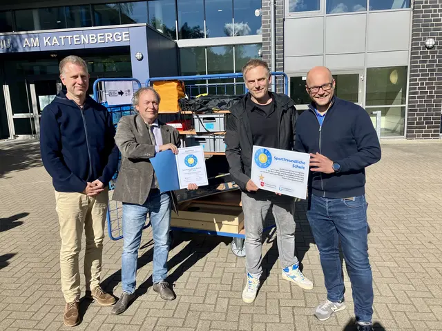 Freude über die Siegel-Verlängerung vor dem Wagen der „Bewegten Pause“, v.l.: GAK-Koordinator Tim Danker, Detlef Zeidler (RLSB), Marc Daburger (Fachobmann Sport GAK) und Fabian Hammerschmidt (stv. Schulleiter).