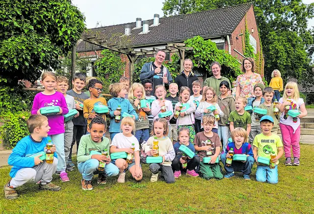 Marktleiter Mirko Strache und seine Stellvertreterin (hinten links) überreichten den Erstklässlern der Grundschule Handeloh die ­Brotdosen mit gesundem Inhalt  | Foto: Grundschule Handeloh