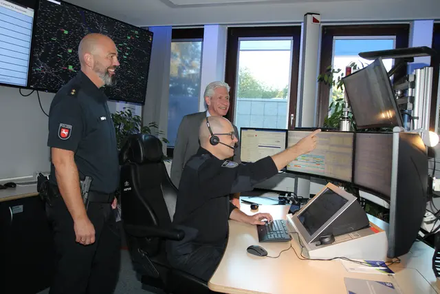 Polizeioberrat Sebastian Pölking (li.), Landrat Rainer Rempe (hi.) mit Florian Fietz in der Rettungsleitstelle | Foto: Landkreis Harburg