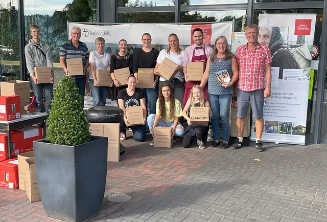 Die Initiatoren Uwe und Karin Bruns (v. re.) mit den Unterstützern der "Pakete zum Leben"-Aktion vor Knolles Markt in Ramelsloh | Foto: Bruns