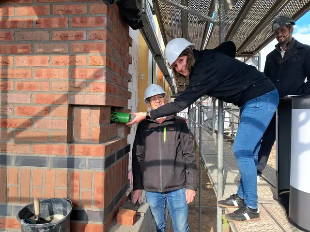 Objektmanagerin Anja Rienow versenkt die Zeitkapsel in der Mauer | Foto: Anika Werner
