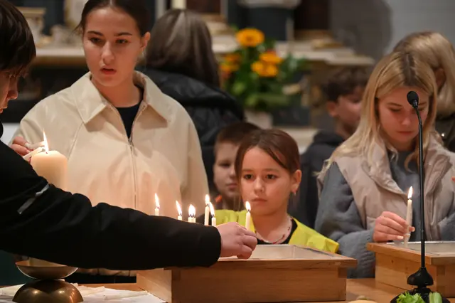 Die Kinder aus Mykolajiw und ihre Mütter zünden am Ende der Andacht am Altar Kerzen für ihre vermissten oder verstorbenen Angehörigen an
  | Foto: Landkreis Stade / Daniel Beneke
