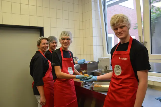Jessica Tietjen und Lorenz, Amatus und Kevin (v.li.) beim Zubereiten des Gemüse-Hähnchen-Mix