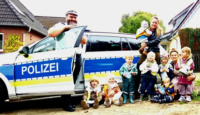 Ein Highlight für die Kinder: Auf Initiative der Tagesmütter Meike Prange (stehend) und Maria Klückmann kam mit dem Präventionsbeauftragten Johannes Droßbach ein richtiger Polizist im Streifenwagen zur Prüfung | Foto: Klückmann