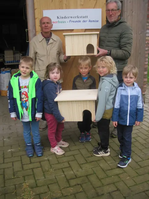 Stolz präsentieren die kleinen Handwerkerinnen und Handwerker mit Jochen Demuth (hi.li.) und Erwin Glockner
die fertigen Igelhäuser | Foto: H. Mügge