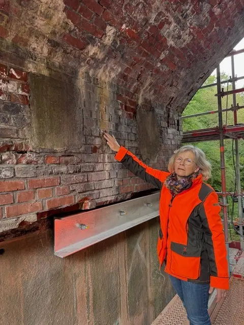 Ortsbürgermeisterin Anke Grabe nimmt die „Tropfsteinhöhle“ in Augenschein. Die Bohrungen für die Stahlträger, die das Mauerwerk abfangen sollen, mussten wegen der starken Nässe im Bauwerk mehrfach abgebrochen werden.  | Foto: M. Grabe