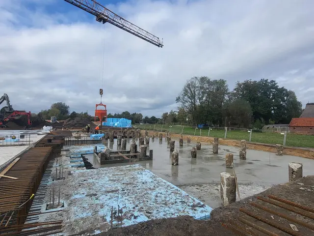 Die Häuser werden auf Pfählen gebaut, rechts im Bild zu sehen. Links daneben ist bereits die Bodenplatte gegossen