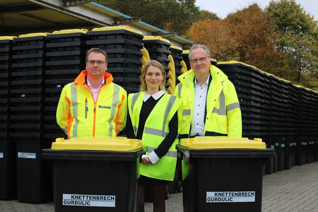 Lars Köhler (Geschäftsführer Nord), Nadine Kuhnigk (Sprecherin) und Alexander Pabst (Prokurist) von Knettenbrech &amp; Gurdulic vor rund 25.000 Gelben Tonnen, die ab 17. November verteilt werden | Foto: pöp