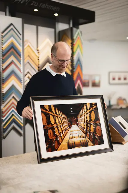 Markus Peter mit einem individuell gerahmten Bild | Foto: www.unanim.de