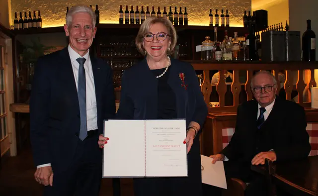 Rainer Rempe (li.) und Anette Kosakowski (re.) mit dem Bundesverdienstkreuz und der Urkunde_Wolfgang Zumpe (hinten) | Foto: jvp
