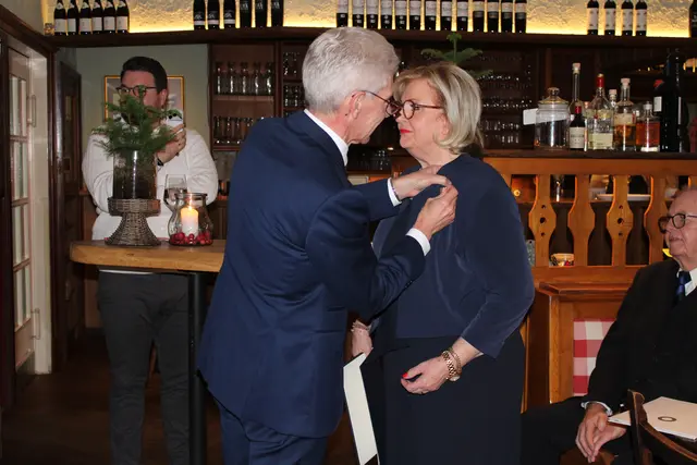 Rainer Rempe (li.) und Anette Kosakowski (re.) beim anbringen des Bundesverdienstkreuzes_Wolfgang Zumpe (hinten re.) | Foto: jvp