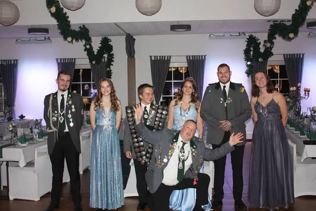 Jungschützenwürden mit Kaiser Olli Thesen 2025 (v. li.): Bester Jungschütze Auflage und Adjutant Jungschützenkönig Lasse Heydorn, beste 
Jungschützin Freihand Johanna Pankel, Jungschützenkönig Kevin Mittag, Jungschützenkönigin 
Leonie Fitschen, Adjutant Jungschützenkönigin Mark Garske, Glückskönigin der Jungschützen 
Maren Allers, im Vordergrund: Kaiser Oliver These

 | Foto: Wiebke Körner