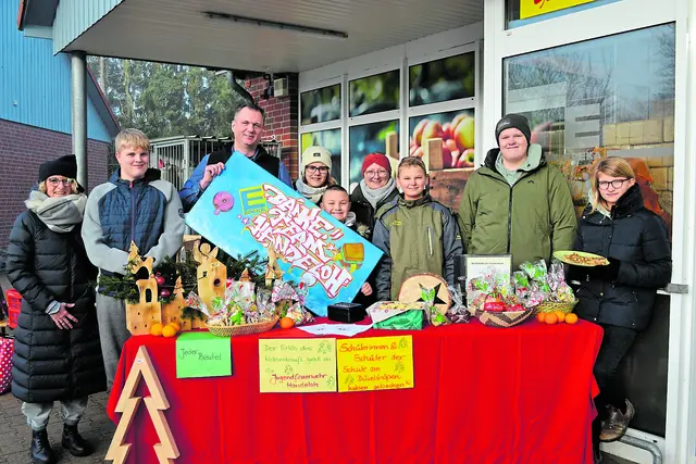 Marktleiter Mirko Strache (3. v. li.) erhielt ein Dankeschön-Plakat von den Jugendlichen der Schule am Düvelshöpen, die von Schulleiterin Anja Scheele (li.) und Lehrerin Sandra Hagemann (4. v. re.) begleitet wurden | Foto: bim