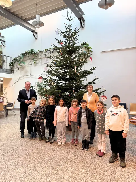 Kinder der zweiten Klassen der Stadtschule freuten sich zusammen mit Bürgermeister André Wiese (li.) und Lehrerin Birgit Platow (hi. re.) über den geschmückten  Weihnachtsbaum.  | Foto: Stadt_Winsen