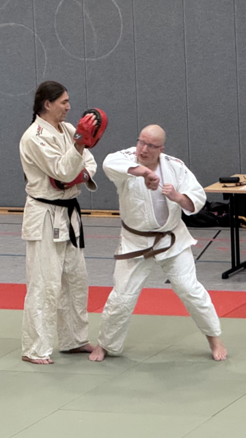 Demonstration von Schlagtechniken mit dem Ellenbogen. Um den Partner zu schonen, trägt dieser Pratzen, um den Schlag abzufedern. | Foto: Jan Eggert