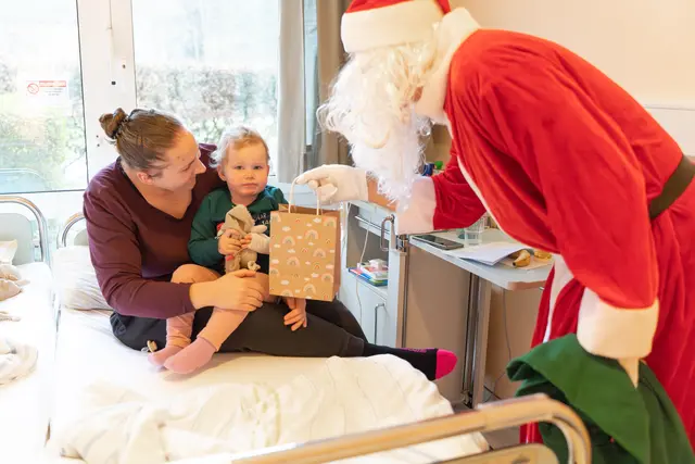 Die kleine Lea und ihre Mutter Annika freuen sich sehr über den Besuch vom Weihnachtsmann in der Kinderklinik | Foto: Elbe Kliniken / Kati Meyer-Thie�dig