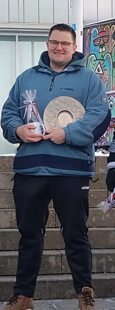 Mathias Fitschen freut sich über den Wanderpokal des Eisstockschießens - den "Flachlandteller" | Foto: Eduardo Frey