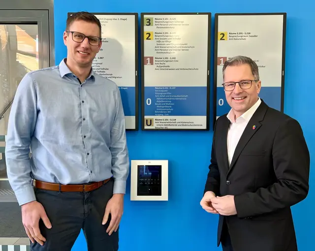 Landrat Kai Seefried (rechts) und Jörn Martens vom Amt Personal und Interner Service zeigen die neue Besucherlenkung im Stader Kreishaus – hier im Eingangsbereich neben der Info | Foto: Landkreis Stade / Nina Dede