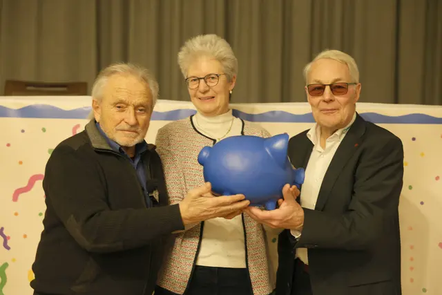 Egon Müller (li.) und Claus Bredehöft überreichen Anke Wolfram das Sparschwein | Foto: SocialArt
