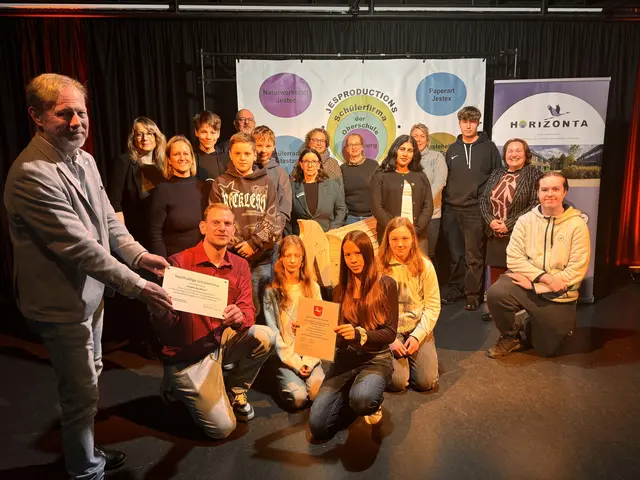 Alex Will, Julien Sum, Lennart Ranft, Beritan Capli, Stian Dech, Haylie Imbeck, Sophie Krüger und Tilda Wigert vertraten die Schüler bei der Übergabe von Urkunde und Schild durch Frank Corleis (li., Schulbehörde) an Lehrer Mirco Dörfler (knieend), hier mit Lehrern und Kooperationspartnern | Foto: Henrik Titze