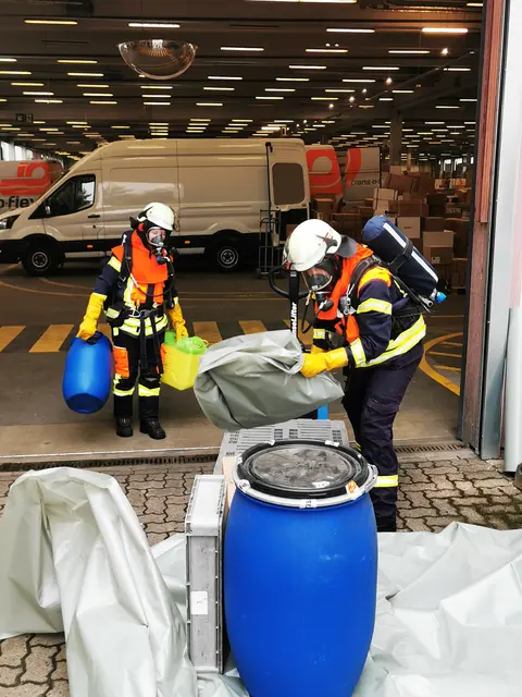 Feuerwehrkräfte unter Atemschutz stellen das beschädigte Gebinde sicher | Foto: FF Maschen