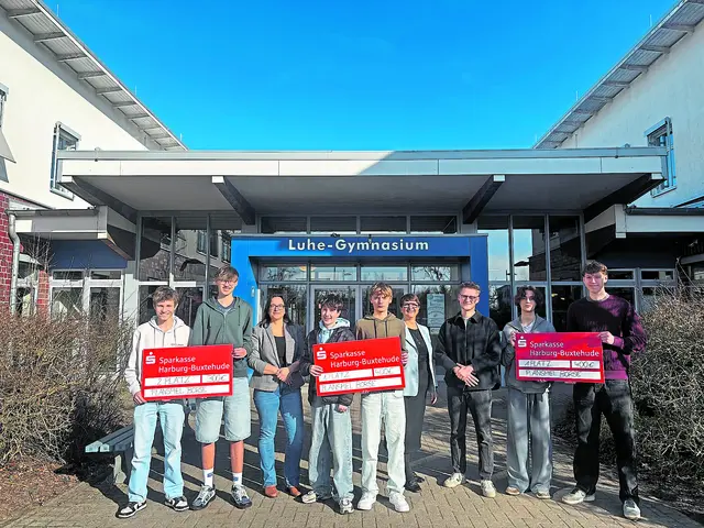 Die glücklichen Siegerteams des Luhe-Gymnasiums mit ihrem Lehrer Niklas Schattenberg und Schulleiterin Kerstin Kuhn (3. und 4. von rechts) sowie Marina Otromke von der Sparkasse Harburg-Buxtehude (3. von links)