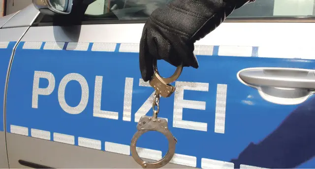 Polizeiwagen und Handschellen (Symbolbild) | Foto: KI generiert